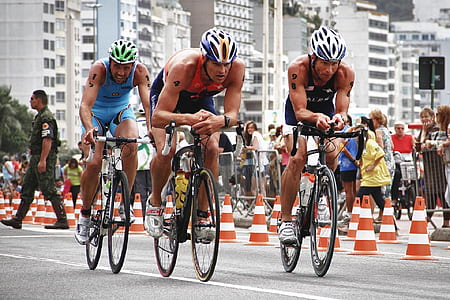 men riding on bike near people watching at daytime thumbnail