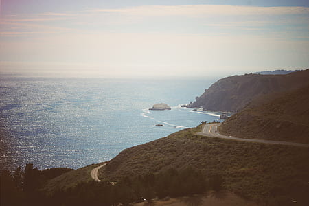 aerial shot photo of mountain near body of water thumbnail