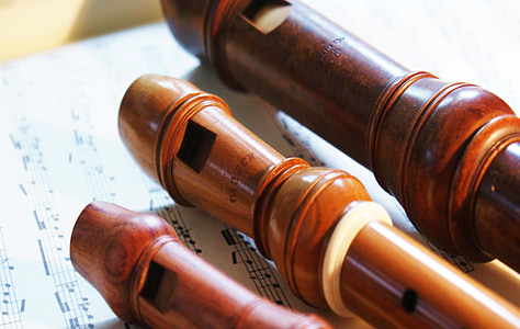 three brown recorder flutes on music sheet thumbnail