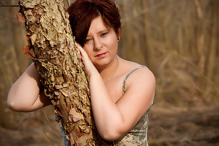 selective focus photography of woman leaning on tree thumbnail