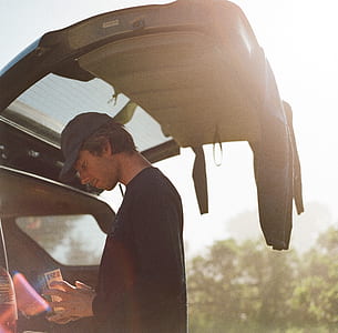 man in black sweater standing on the back of the vehicle thumbnail
