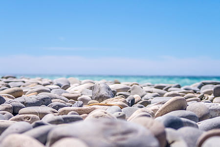 selective focus photo of stones near body of water thumbnail
