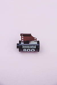 black and silver Lomography lens cartridge on beige surface thumbnail