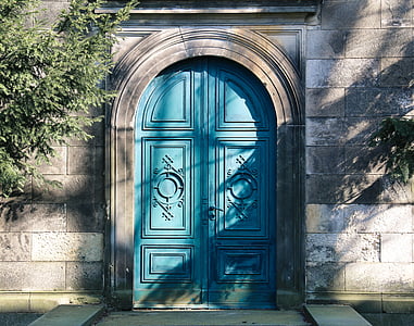 blue wooden french door and gray concrete building near green plant thumbnail