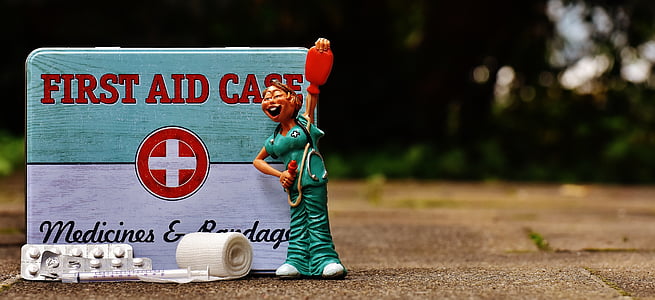 selective focus photography of First Aid Case with nurse figurine thumbnail