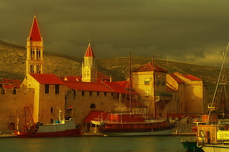 boats near brown concrete building during daytime thumbnail