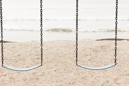 two gray steel swinging bench beside body of water thumbnail