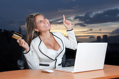 woman in white and black blazer smiling while sitting thumbnail