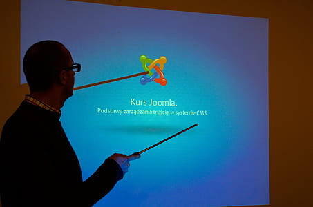 man standing near projection screen thumbnail