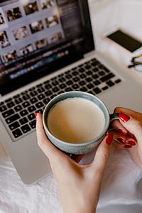 A woman works at a desk with a laptop and a cup of coffee thumbnail