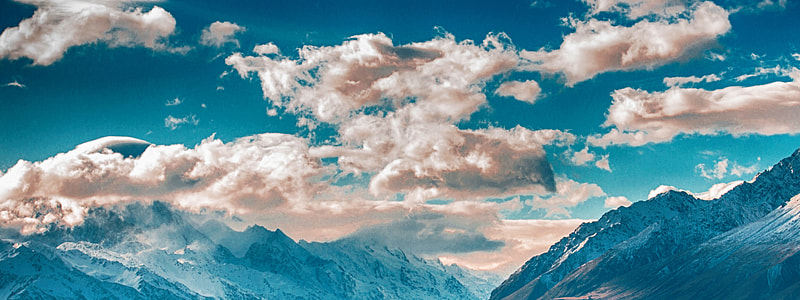 mountain range under partially cloudy skies thumbnail