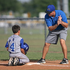 selective focus photography of man in blue collared shirt in front of boy kneeling on brown sand thumbnail