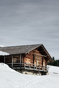 brown wooden house on white snow during daytime thumbnail