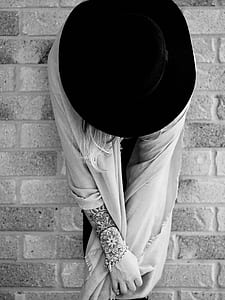 woman in scarf and black cap against brick wall thumbnail
