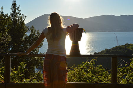 woman wearing white shirt looking at body of water thumbnail