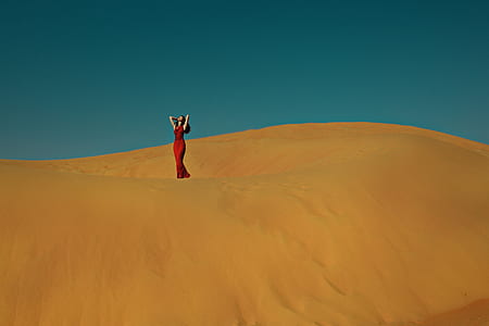 woman standing on desert under calm blue sky thumbnail