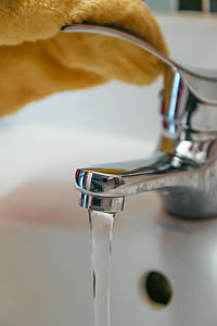 selective focus grey stainless steel faucet pouring water thumbnail