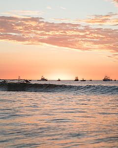 ships in body of water during golden hour thumbnail