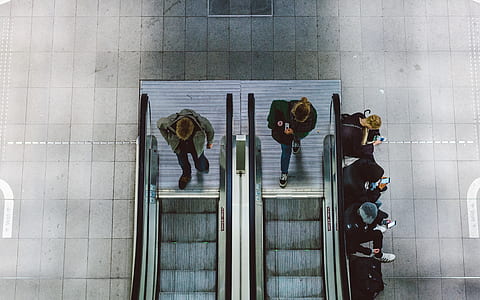 man and woman about to step on escalator thumbnail