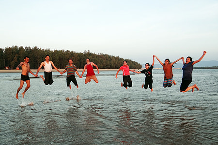 group of people jumping above body of water thumbnail
