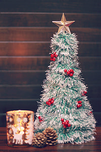 selective focus photography of silver and red decorative chrismas tree with star above and two pine fruits thumbnail