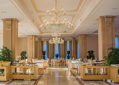 empty chairs and table arrangement and uplight chandelier building interior thumbnail