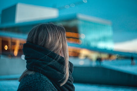 selective focus photography of woman standing near building thumbnail