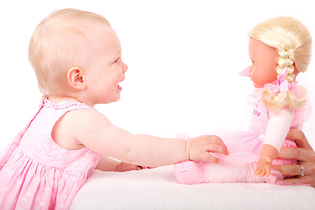 photo of baby in pink dress playing with girl doll thumbnail