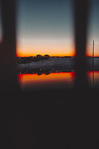 silhouette building reflecting on body of water thumbnail