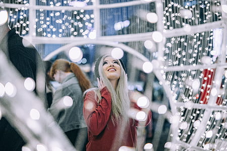 woman looking up through white string lights thumbnail