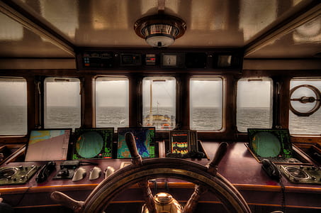 ship's wheel in front of stormy sea thumbnail