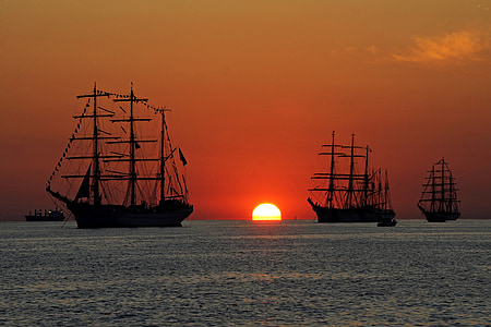three galleon on body of water during sunset thumbnail