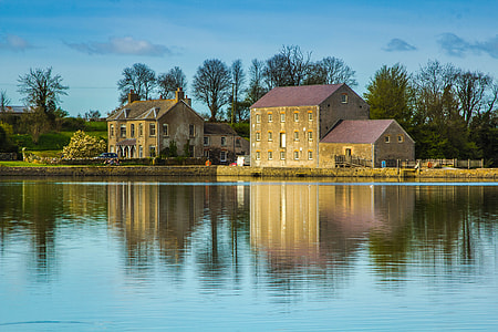 landscape photography of brown house near body of water thumbnail