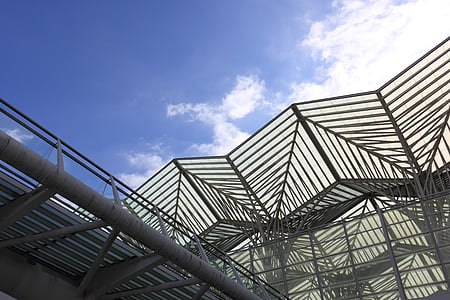 low-angle photo of grey metal building under blue cloudy sky thumbnail