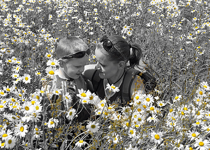 grayscale photo of woman and boy sitting on grass thumbnail