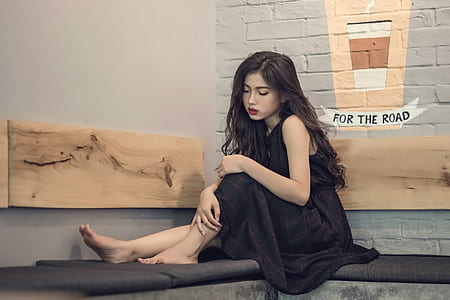 woman in black sleeveless dress sitting thumbnail