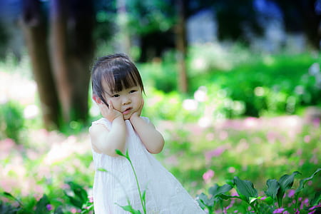 girl in white dress holding her cheek thumbnail