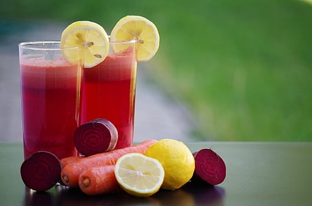 selective focus photography of two glass of juices with lemon and carrots thumbnail