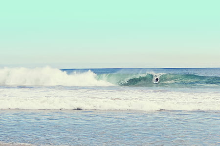 person surfing on waves during daytime thumbnail