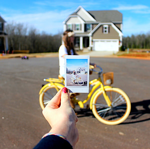 person holding photo of woman riding bike thumbnail