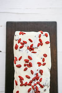 flat-lay photography of white icing coated pastry with nuts thumbnail