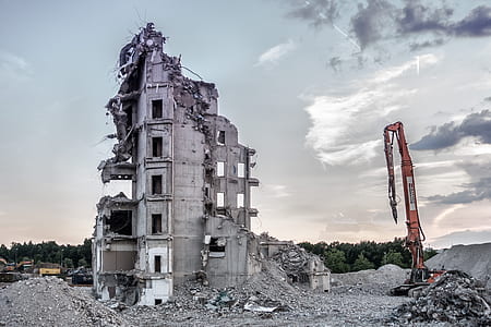 orange jackhammer heavy equipment near a building ruin at daytime thumbnail