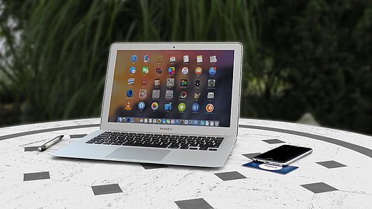 MacBook Air beside space gray iPhone 6 on top of table thumbnail