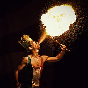 photo of man holding stick with fire thumbnail