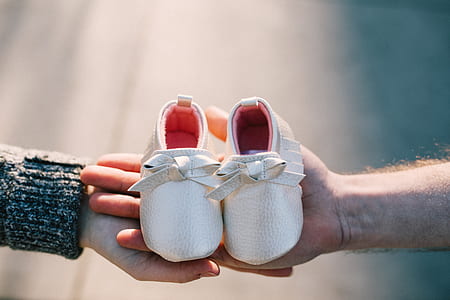 person holding pair of white shoes thumbnail
