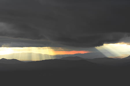 sunrays through clouds with mountain silhouette thumbnail