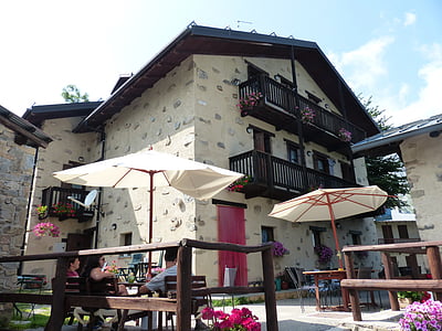 group of people sitting under patio umbrella beside house thumbnail