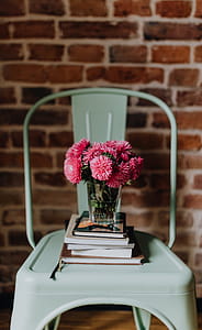 Industrial metal chair with a bouquet of pink flowers and books on it thumbnail