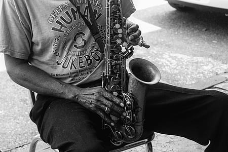 grayscale photo of man playing saxophone thumbnail