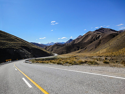empty road in middle of mountain terrain thumbnail